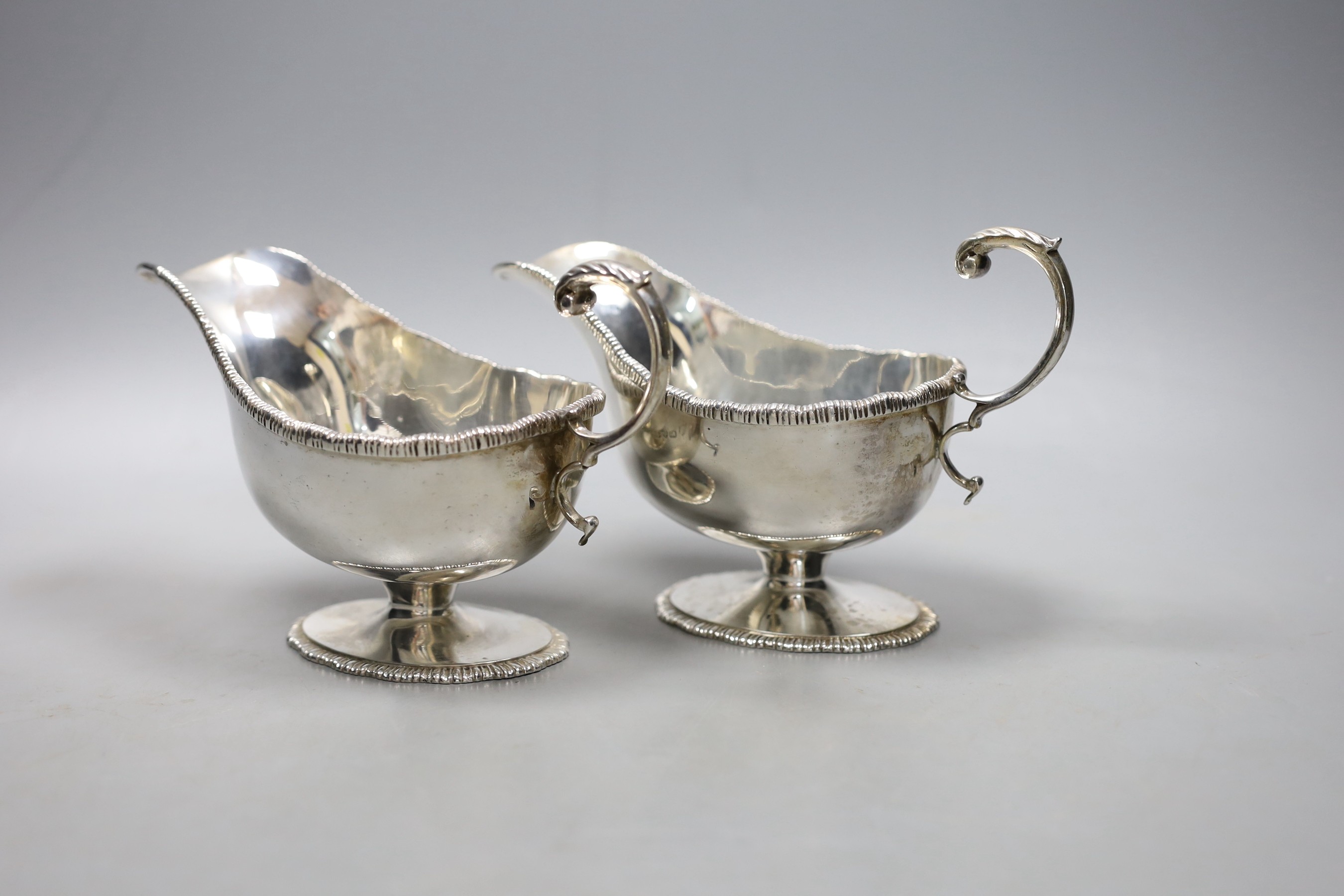 A pair of George V silver pedestal sauceboats with flying scroll handlse, Parker Brothers, Chester 1911, 14oz.